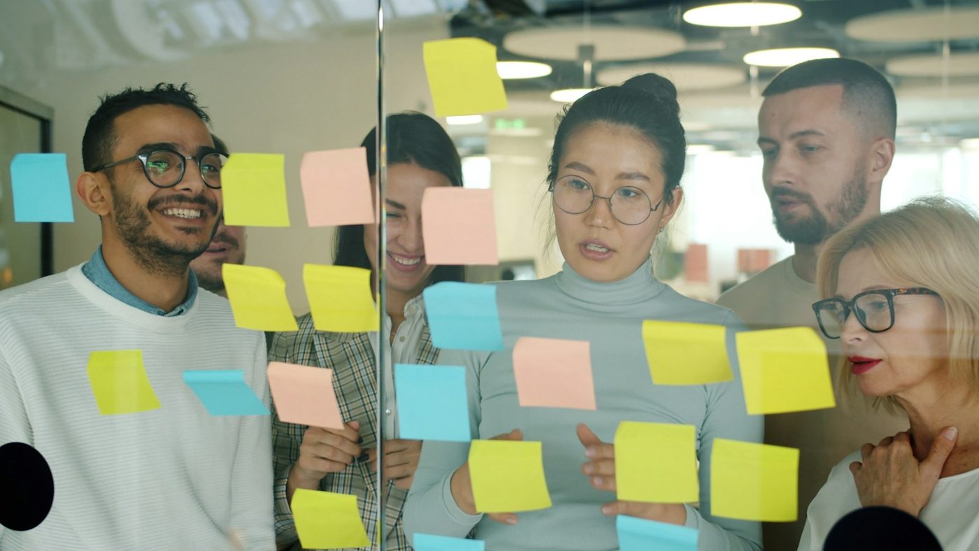 A team brainstorming with sticky notes on a glass wall
